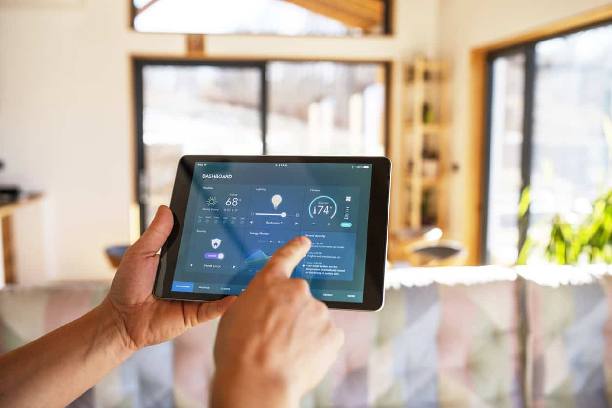 Homme controlant sa maison connectee depuis une tablette
